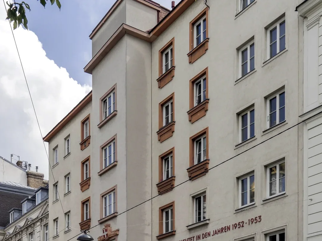 Wohnanlage mit vielen Fenstern, Balkonen und mehreren Wohnungseinheiten
